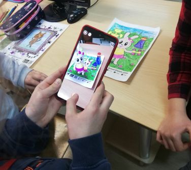 dłonie ucznia, trzymające smartfon z otwartą aplikacją