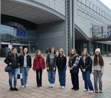 grupa nastolatek pozuje do zdjęcia przed budynkiem parlamentu europejskiego