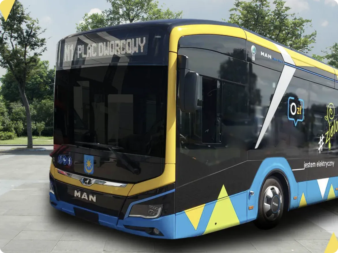 Nowoczesny miejski autobus elektryczny MAN w kolorach czarnym, niebieskim i żółtym z napisem "M1 PLAC DWORCOWY" na wyświetlaczu przednim.