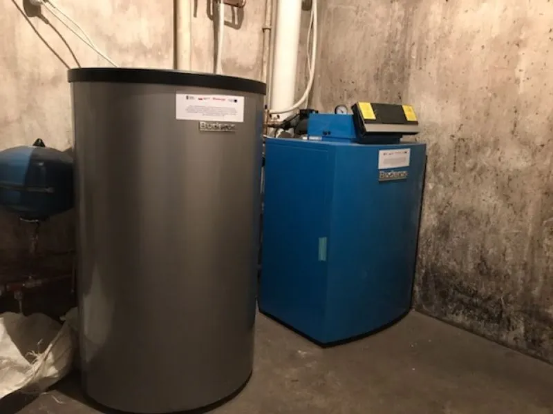 Szare i niebieskie urządzenia grzewcze stojące na betonowej podłodze przy betonowej ścianie.