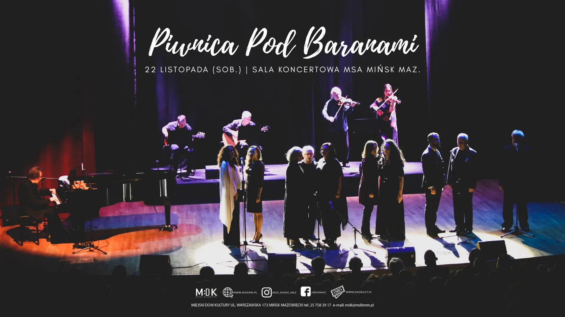 Grupa muzyków i śpiewaków na scenie w sali koncertowej, oświetlonych jasnymi reflektorami, z ciemnym tłem i fioletowymi zasłonami. Po lewej stronie pianista przy fortepianie, w tle dwóch gitarzystów i dwóch skrzypków. Na pierwszym planie dziewięć osób stojących przed mikrofonami. Publiczność widoczna w cieniach na dole zdjęcia. Tekst zapowiadający wydarzenie „Piwinca Pod Baranami” oraz datę i miejsce koncertu.
