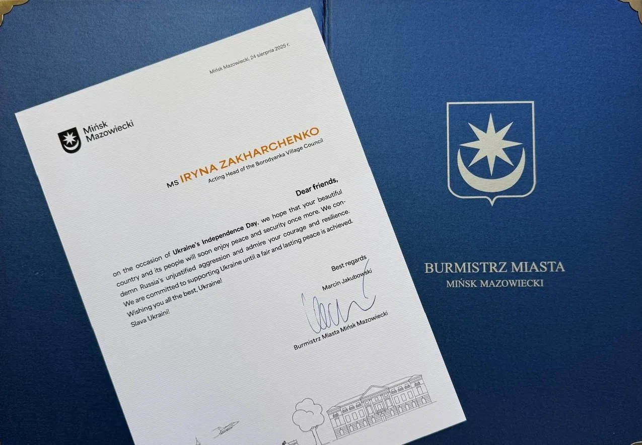 List skierowany do Iryny Zacharchenko od burmistrza Mińska Mazowieckiego na niebieskim tle z herbem miasta.