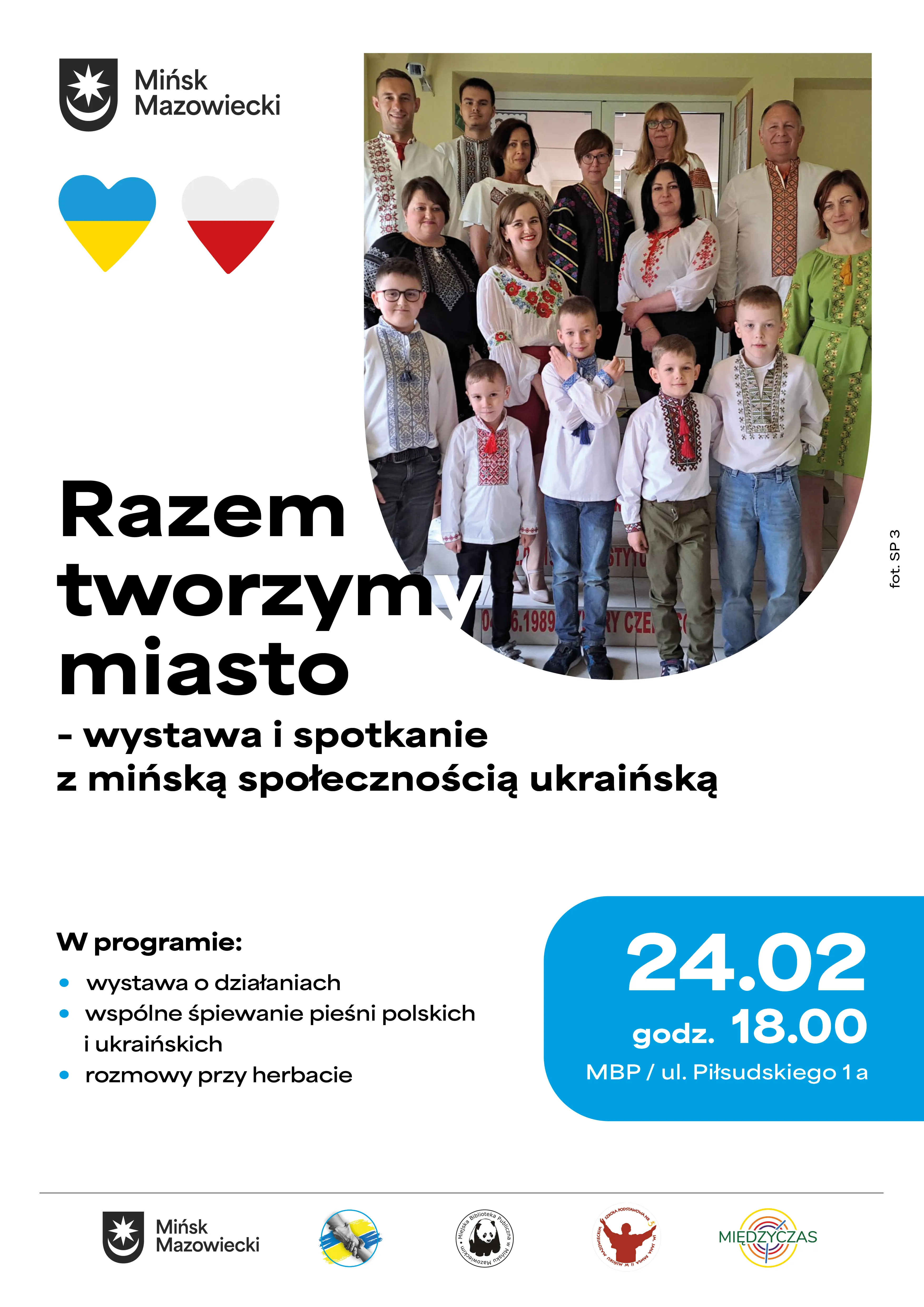 Grupa kilkunastu osób w przedsionku, dorośli i dzieci stoją w kilku rzędach. Wszyscy noszą haftowane tradycyjne koszule i jasne ubrania. Po lewej u góry widoczne jest logo miasta i dwa serca w kolorach Ukrainy i Polski. Plakat ma biało-niebieskie tło i wyraźne niebieskie pole z datą wydarzenia. Na dole widoczne są logotypy organizatorów.
