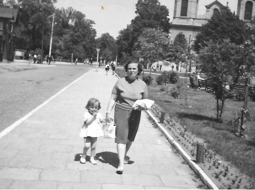 Mama i córka spacerują ulicami miasta, fotografia czarno-biała