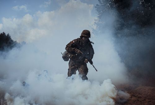 Żołnierz Wojska polskiego na ćwiczeniach w kłębach dymu.