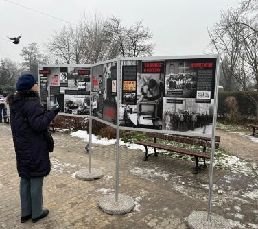 Przechodzień czyta informacje z wystawy.