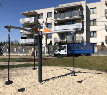 Plac zabaw w ciągu dnia. W tle jasny blok