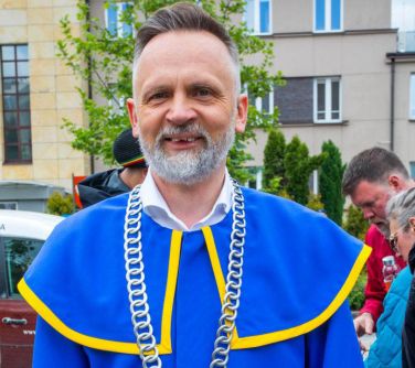 Dzień, pochmurno. uśmiechnięty mężćzyzna w niebieskiej todze