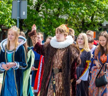 Dzień, słońce. Grupa dzieci w przebraniac z poprzedniej epoki