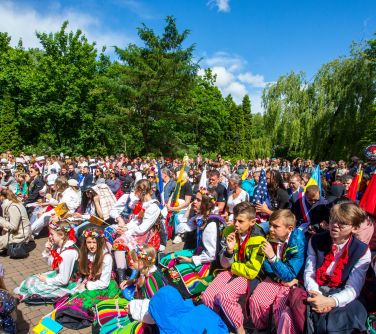 Słoneczny dzień. Osoby w przebraniu siedza na ławkach