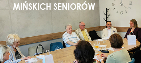 Seniorzy i burmistrz miasta siedzą przy stole