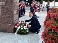 Burmistrz składa kwiaty przed pomnikiem
