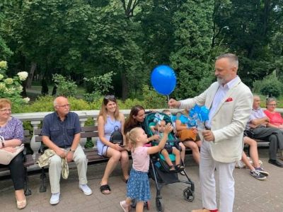 burmistrz rozdający balony i wiatraczki dzieciom