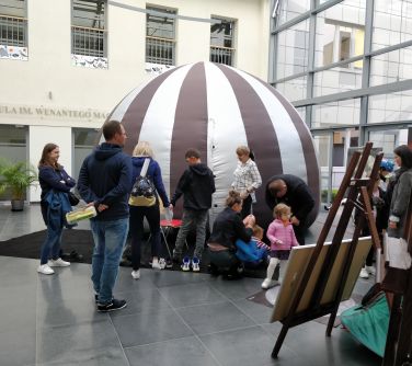 goście odwiedzający miniplanetarium, w tle namiot planetarium