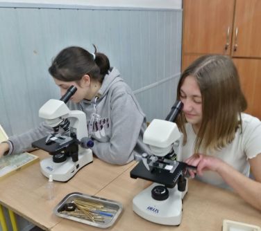 dwie dziewczynki patrzą przez mikroskopy