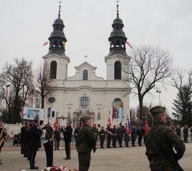 zdjecie złożonych wiązanek, w tle kościół