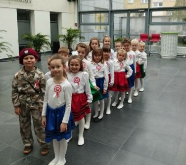 grupa dzieci z przedszkola stojąc z parach pozuje do zdjecia