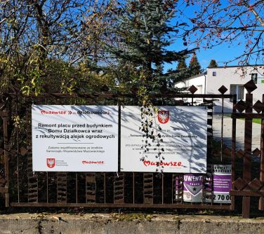 tablice informacyjne o dofinansowaniu projektu wisząca na ogrodzeniu ogródka działkowego