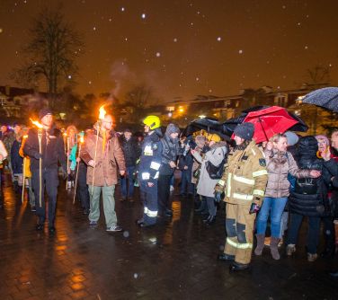 osoby stoją po bokach, zrobiony szpaler dla osób z pochodniami