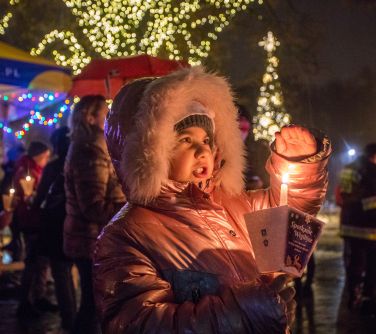 dziecko zakrywa ręką lampion