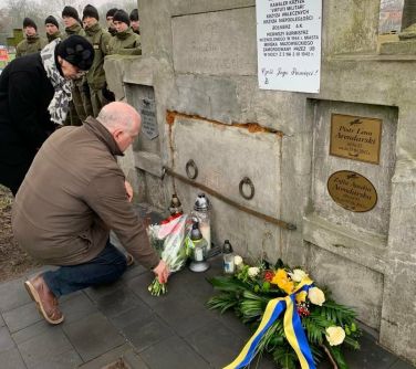 mężczyzna składa bukiet przy grobie