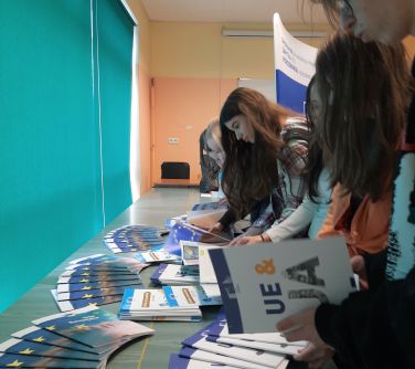uczniowie oglądaja książki o Unii Europejskiej rozłożonych na stole