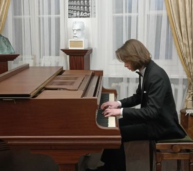 nastolatek w garniturze gra na fortepianie