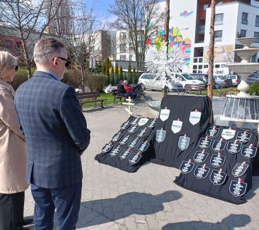 dwie osoby stoja przed tablicami z przyczepionymi plakietkami