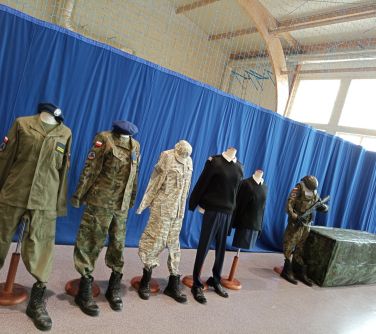 zdjęcie manekinów ubranych w mundury, za nimi wisi niebieska płachta