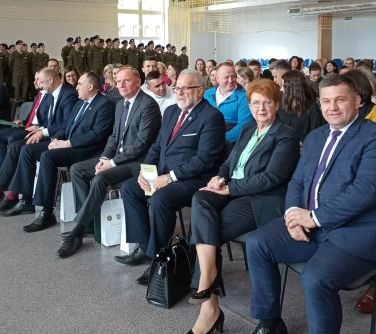 osoby siedzą na krzesłach