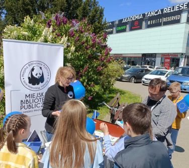 mobilny punkt informacji europejskiej kobieta rozdaje ulotki