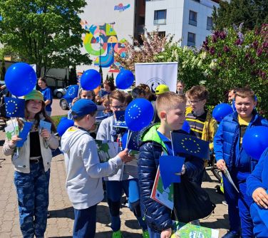 dzieci ubrane trzymają balony