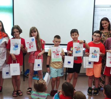 grupa dzieci pozuje do zdjęcia po prawej stronie w grupie kobieta