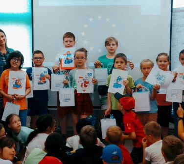 grupa dzieci pozuje do zdjęcia po stronie stronie w grupie kobieta