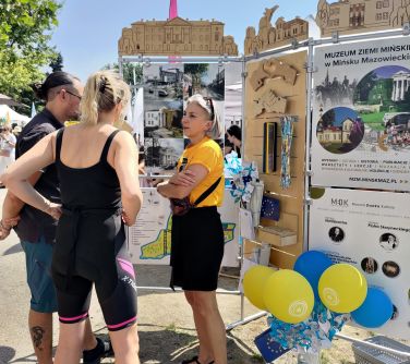 kobieta opowiada mężćzyźnie i kobiecie o wystawie o mieście