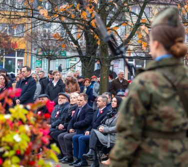 tyłem żołnierka w tle goście uroczystości siedzą na krzesłach