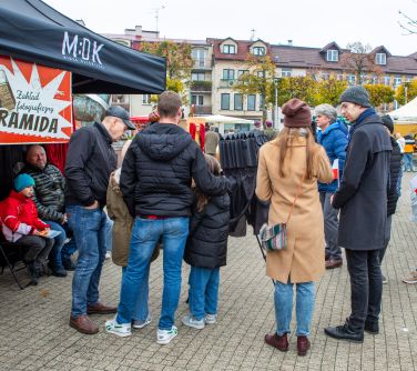 osoby robią sobie zdjęcie w starym aparacie fotograficznym, po lewej osoby siedzą na krześlę przed obiektywem pod namiotem...