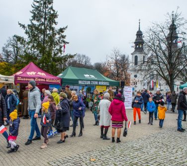 plac starego rynku, na środku ludzie, naokoło namioty, w tle zarys kościoła