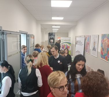 Korytarz wypełniony rozmawiającymi osobami