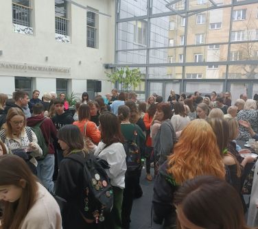 Patio z dużą przeszkloną ścianą wypełnione osobami