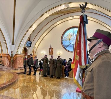 Wnętrze Kościoła. Żołnierze ze sztandarem. Na przodzie ułani. W ścianie duże okrągłe okno