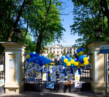 Dwór. Na bramie niebiesko-żółte balony, plakaty z powitaniem w różnych językach. Po środku napis jesteśmy Europą