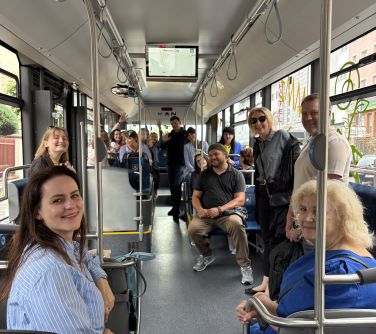 Wnętrze autobusu. Grupa osób pozuje. Część stoi, część siedzi