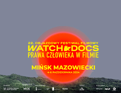 Na tle nieba i na dole zieleni po środku duże czerwone koło. Na nim zółte napisy
